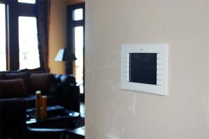 Photo of Media Room Wall showing Crestron Touchpanel for whole-house automated control of Audio, Video, and Control Systems