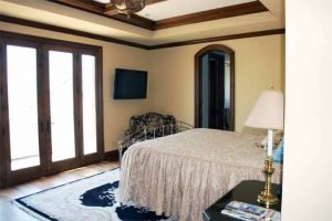 Guest Bedroom with ceiling speakers and television installed and Touchpanel control of Audio, Video, and Control Systems