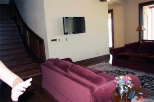 Lower-level Sitting Room with ceiling speakers and television installed and Touchpanel control of Audio, Video, and Control Systems